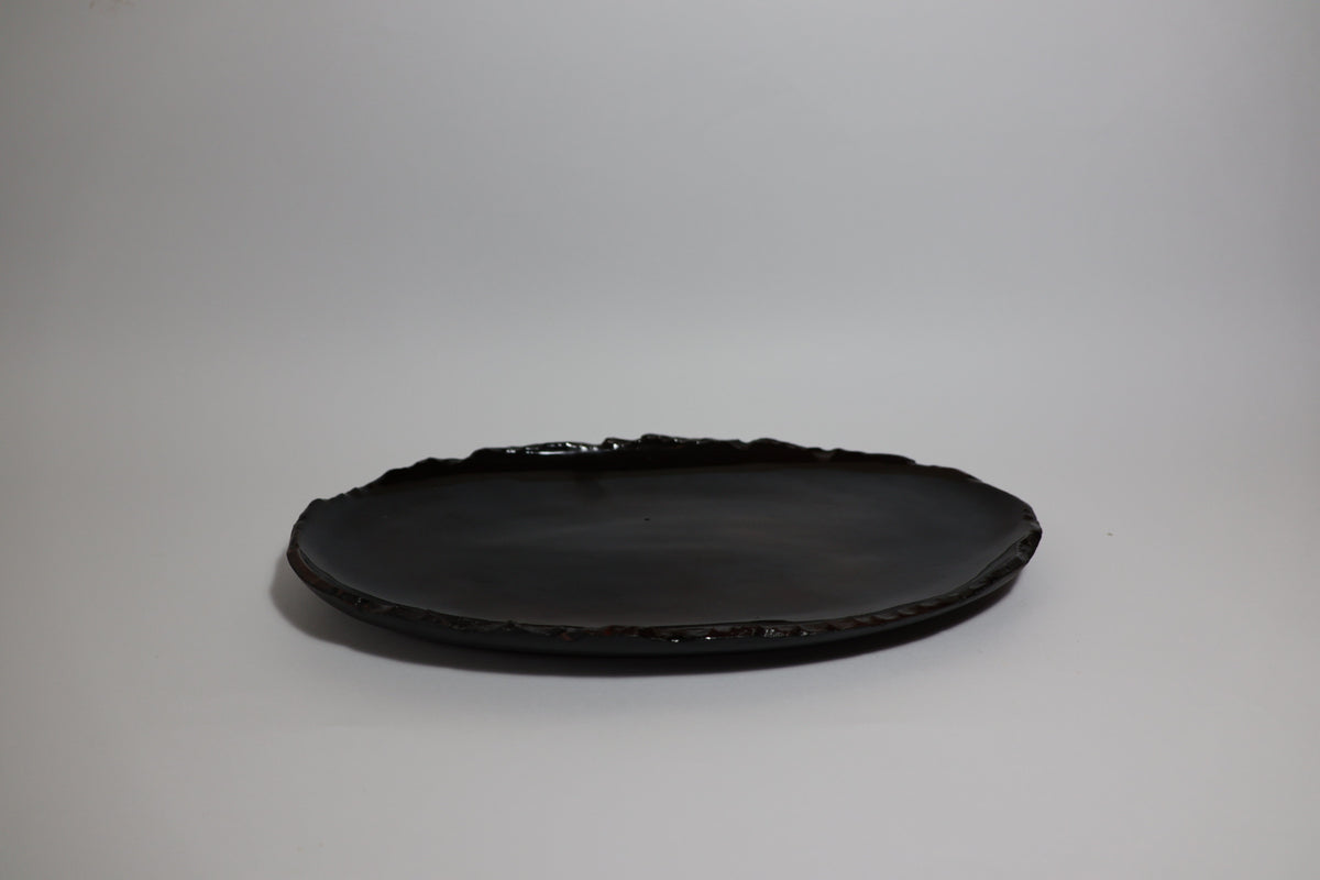 iSithebe black oval ceramic serving platter with a textured irregular rim
