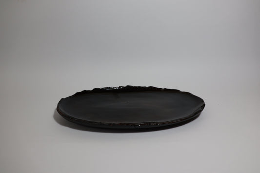 iSithebe black oval ceramic serving platter with a textured irregular rim